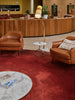 Two brown leather armchairs in a lounge area.