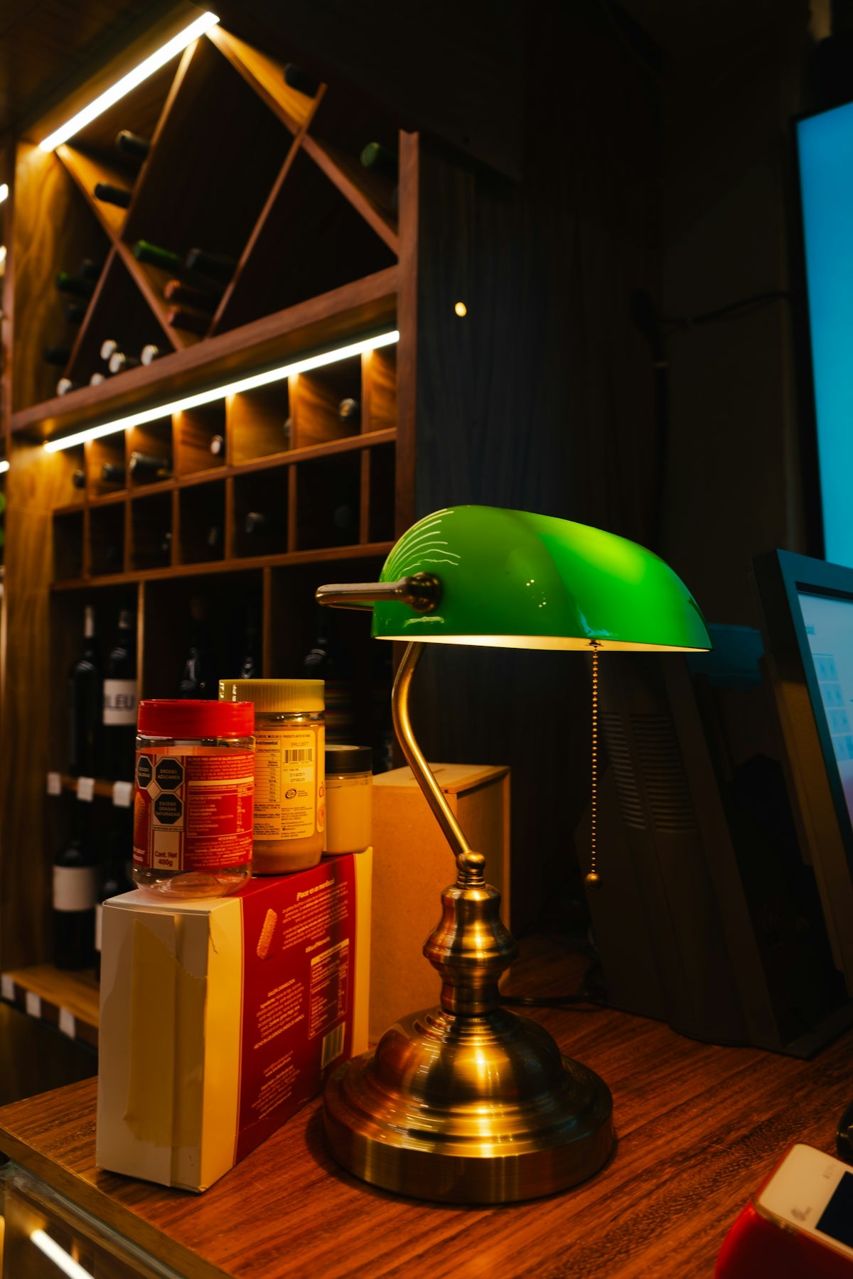 Green banker's lamp on a wooden desk.