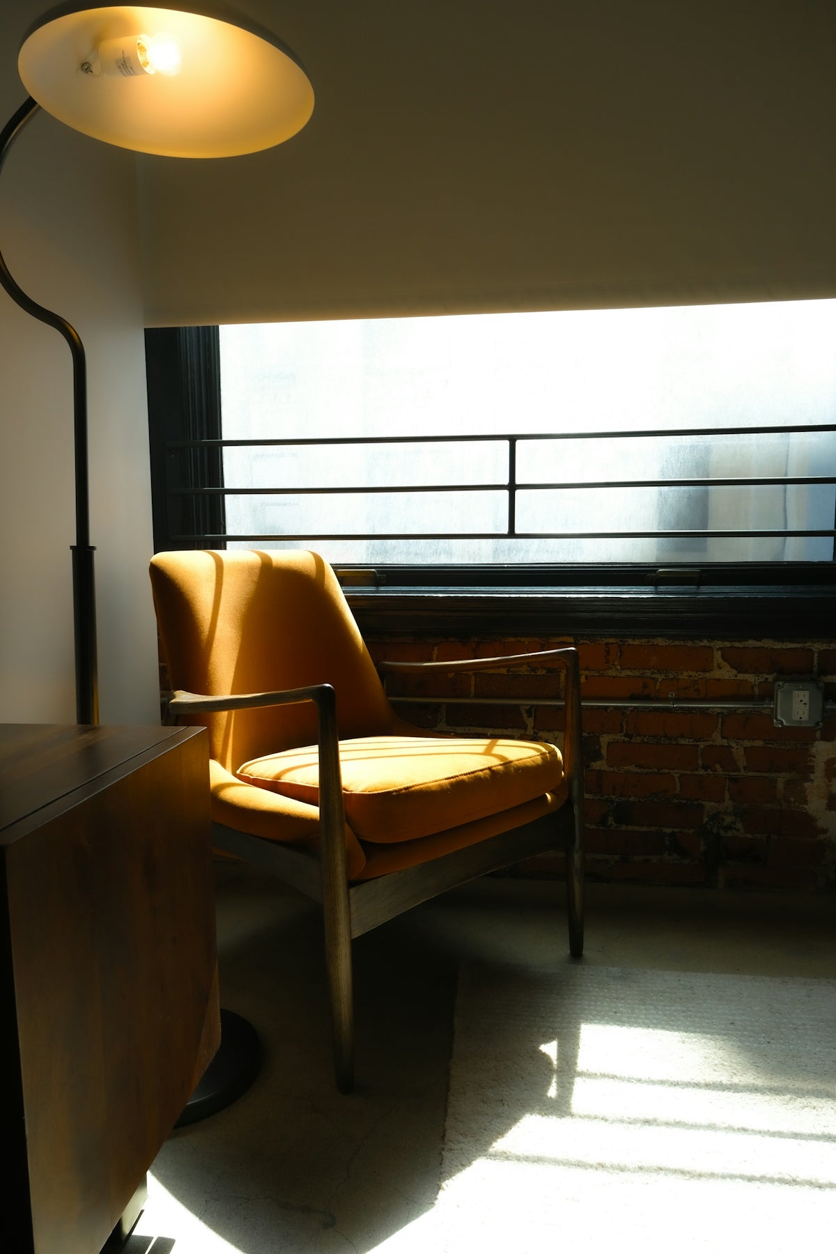 Orange armchair bathed in sunlight near a window.