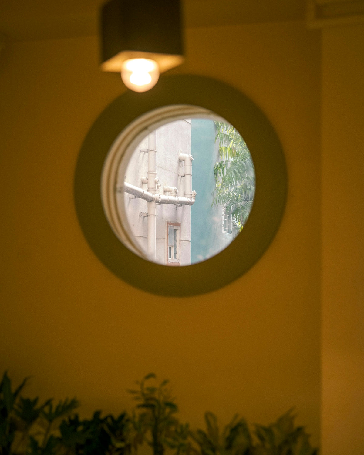 Round window looking out at building details.