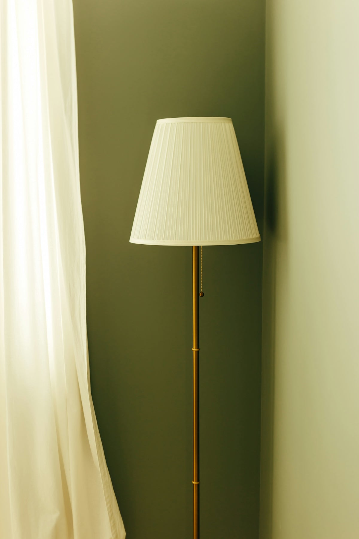 A tall floor lamp with a white shade.