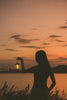 Silhouette of woman holding lantern at sunset