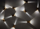 Modern wall sconces casting light patterns on wall