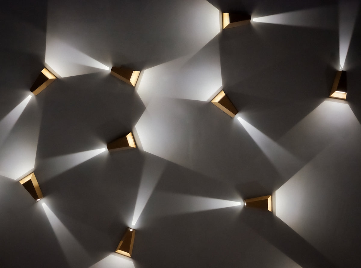 Modern wall sconces casting light patterns on wall