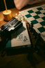 Chessboard, camera, and book on wooden table