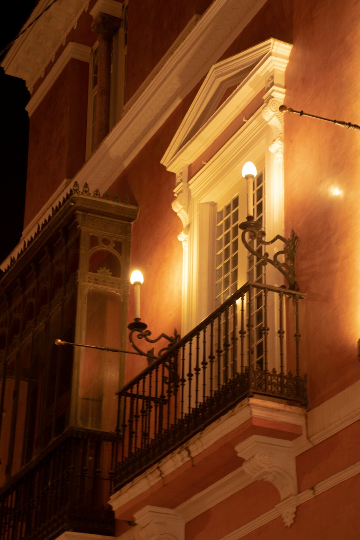 Ornate balcony with antique lamps at night