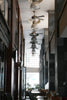 Ceiling fans line a modern hallway with tables below.