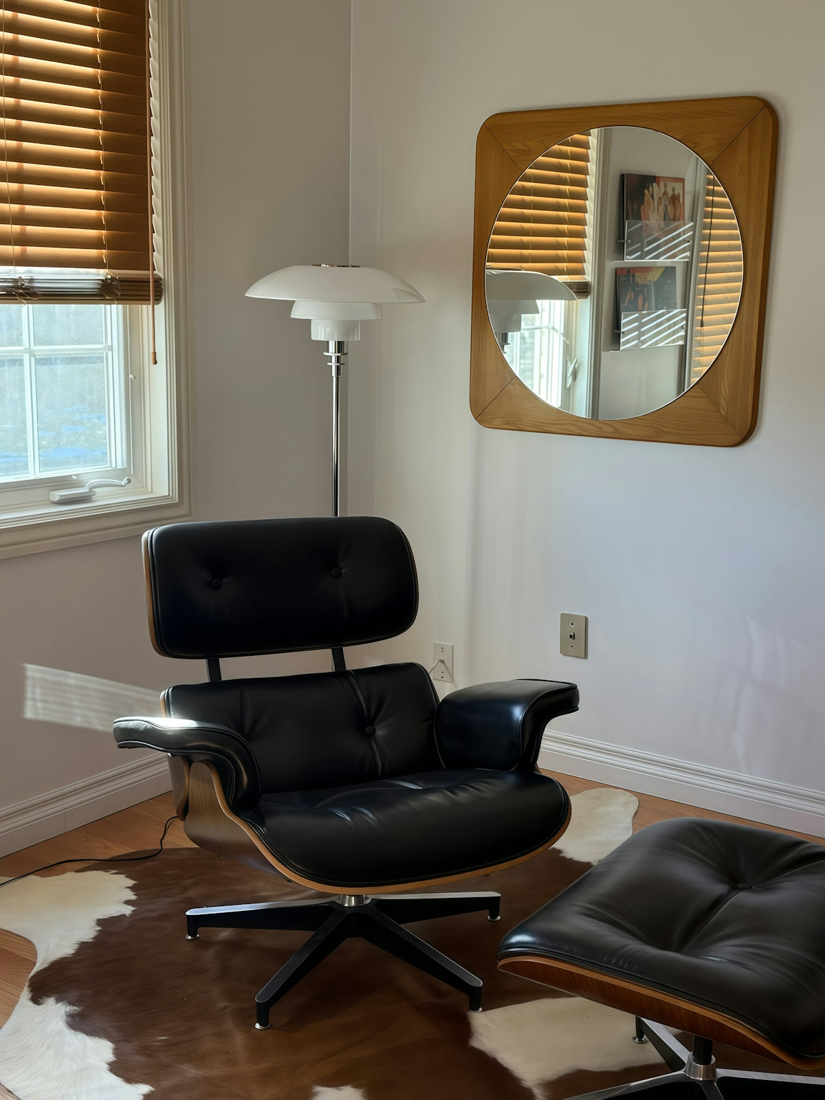 Black leather lounge chair with ottoman and floor lamp.