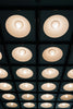 Recessed ceiling lights illuminate a dark room.