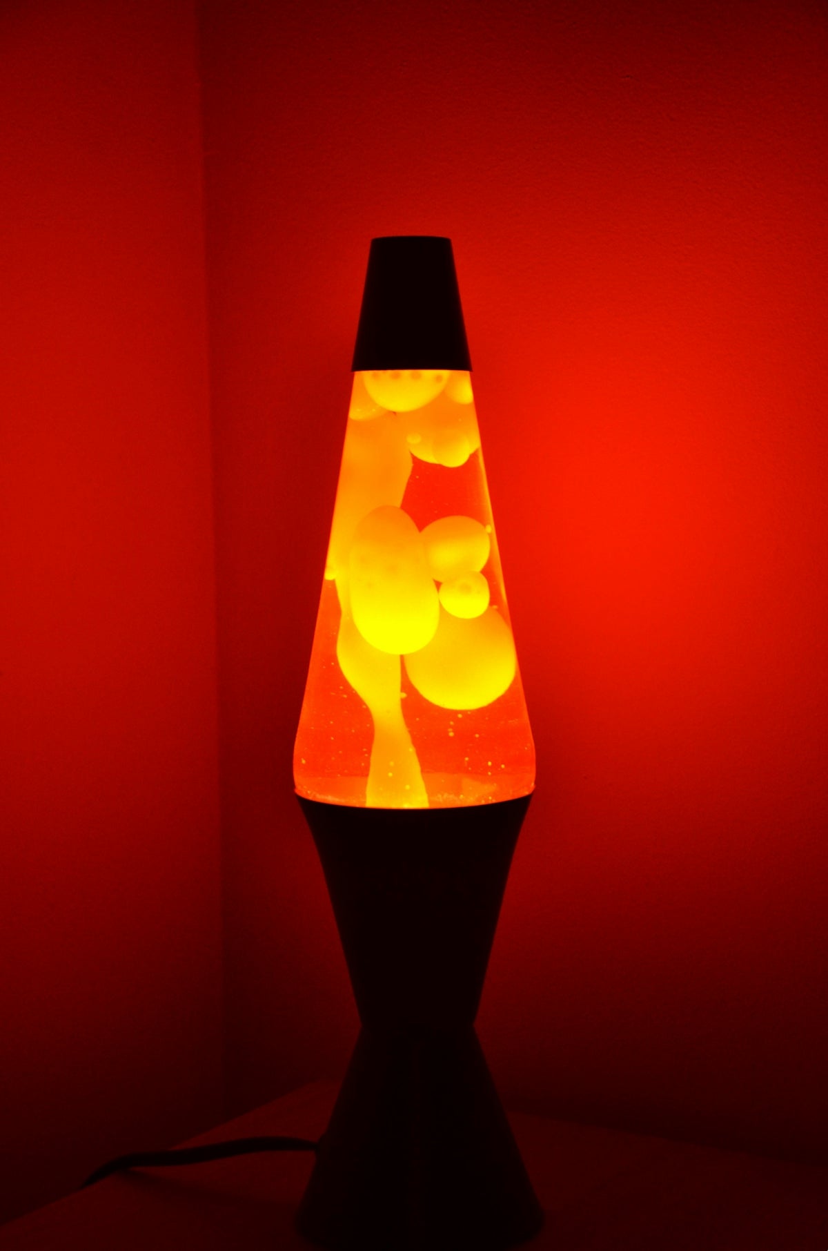 A lava lamp glows with orange and yellow blobs.