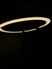 A modern ring-shaped light fixture against darkness