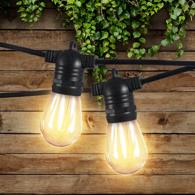 Premium outdoor lighting solutions with decorative bulbs hanging against a wooden backdrop